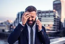 رجل يعاني من توتر خلال مكالمة هاتفية