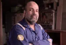 رجل يرتدي زي عمل في ورشة عمل.