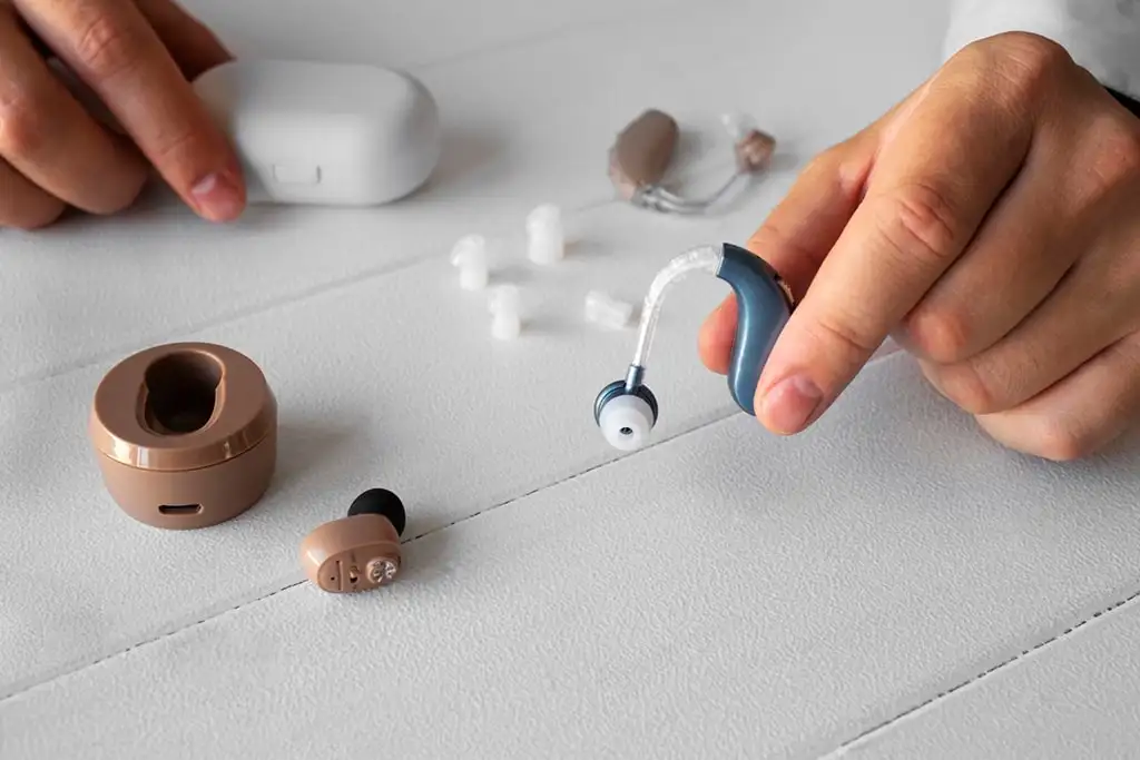 Aides auditives modernes sur une table blanche.