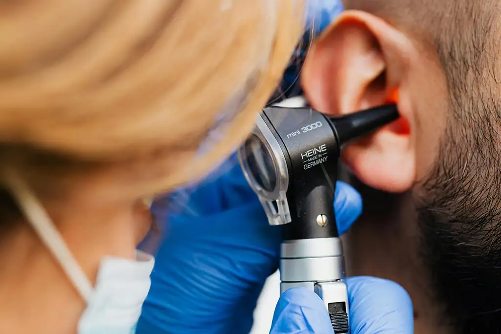 Examen auditif avec otoscope chez le médecin.